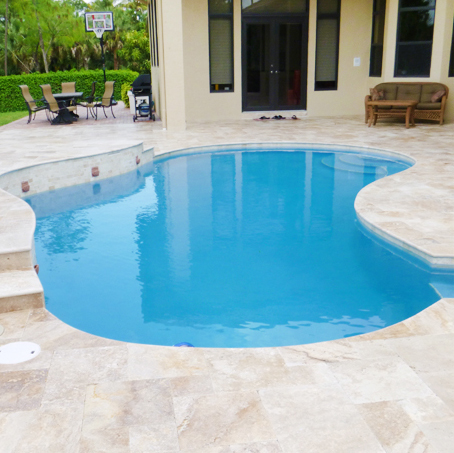 Travertine pavers around a swimming pool by Cliff's Pool in South Florida